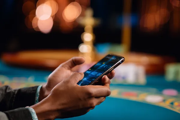 A player using their smartphone during a festive local event, representing DECO X50’s fully mobile-friendly casino.