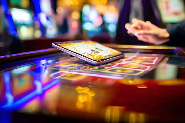 A person using their device against a moody casino-themed background, illustrating the smooth re-entry process at DECO X50.